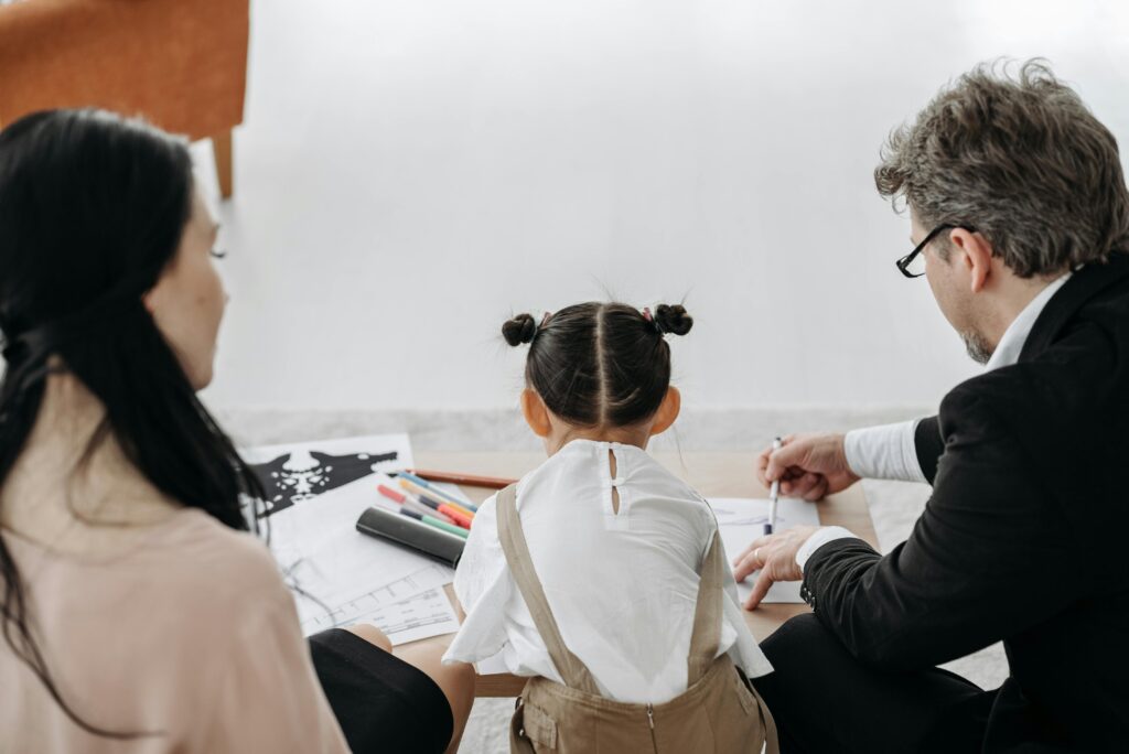 Family bonding session with parents and child drawing indoors. Engaging creative activity.