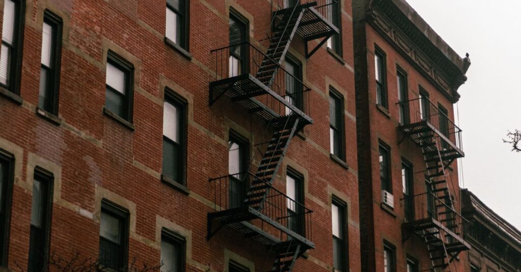 Brick residential building featuring traditional fire escapes and windows.