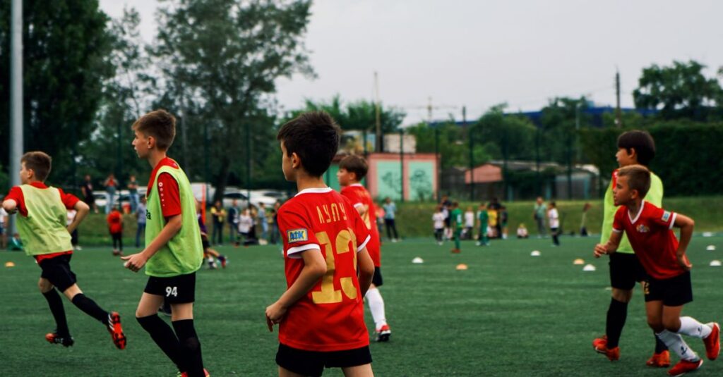 Young kids playing soccer on a green field during the day. Engaged in a fun sporting activity.