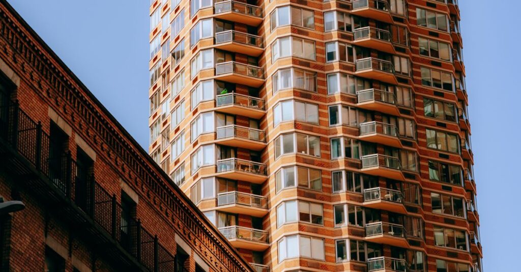Modern high-rise tower with glass windows against clear sky.