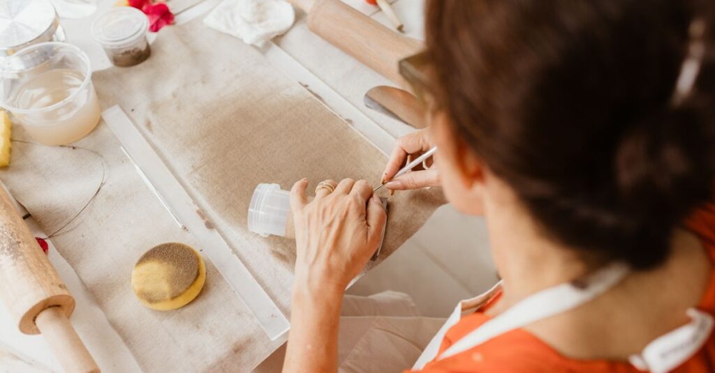 Adult woman crafting with fabric and tools indoors, showcasing creativity and skill.