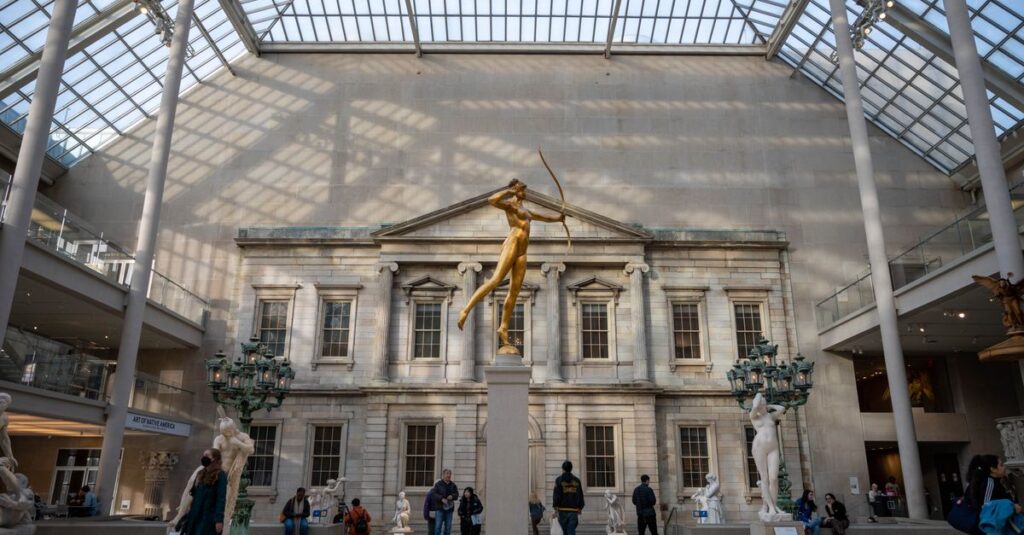 Elegant interior shot of The Met's sculpture gallery showcasing classical architecture and sculptures.