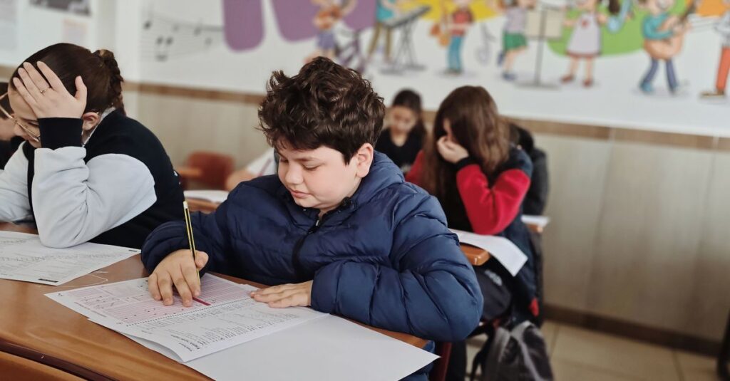 A group of children taking a test with focus and concentration in a classroom setting.