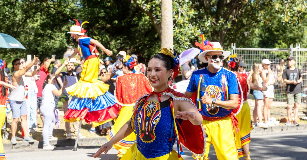 Vibrant street parade with joyful participants in colorful costumes.
