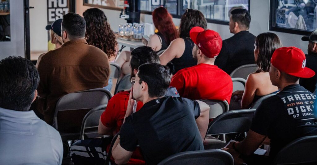 A diverse audience attentively participates in an indoor seminar setting, highlighting education and engagement.