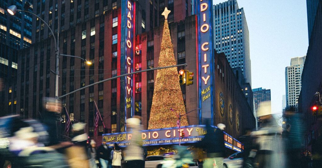 Radio City Music Hall decorated for Christmas in New York City with a lit Christmas tree and bustling crowds.