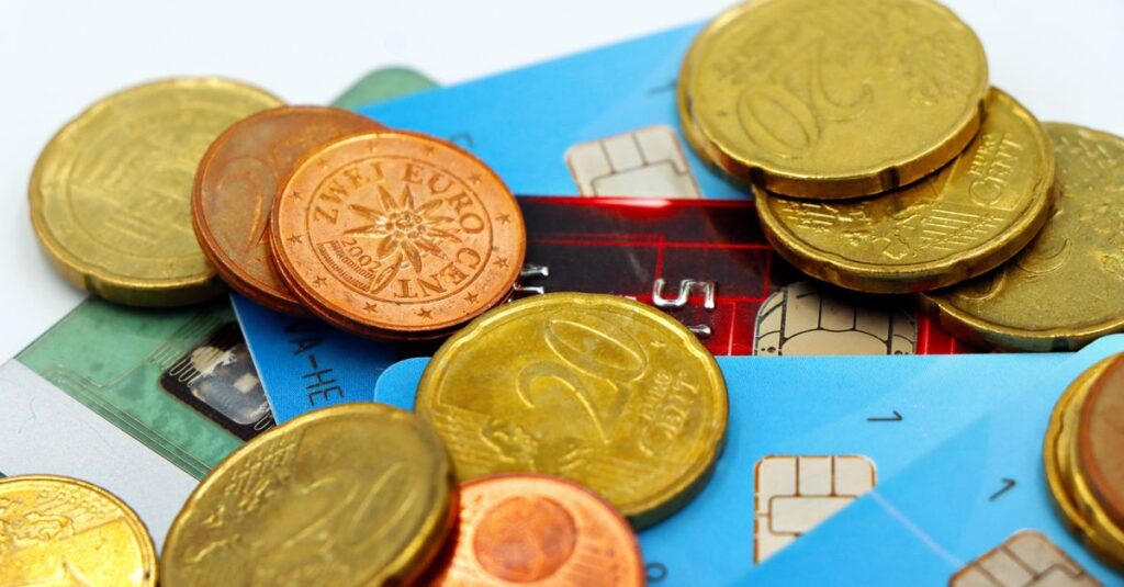 Close-up image of Euro coins and credit cards representing modern financial transactions.