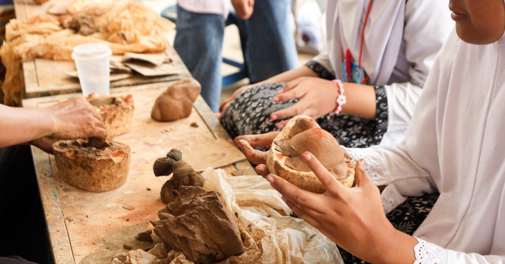 Young individuals participating in an interactive pottery class with hands-on clay molding.