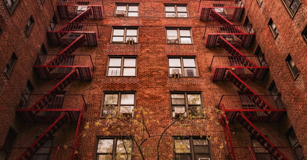 View of iconic red brick apartments with fire escapes in New York.