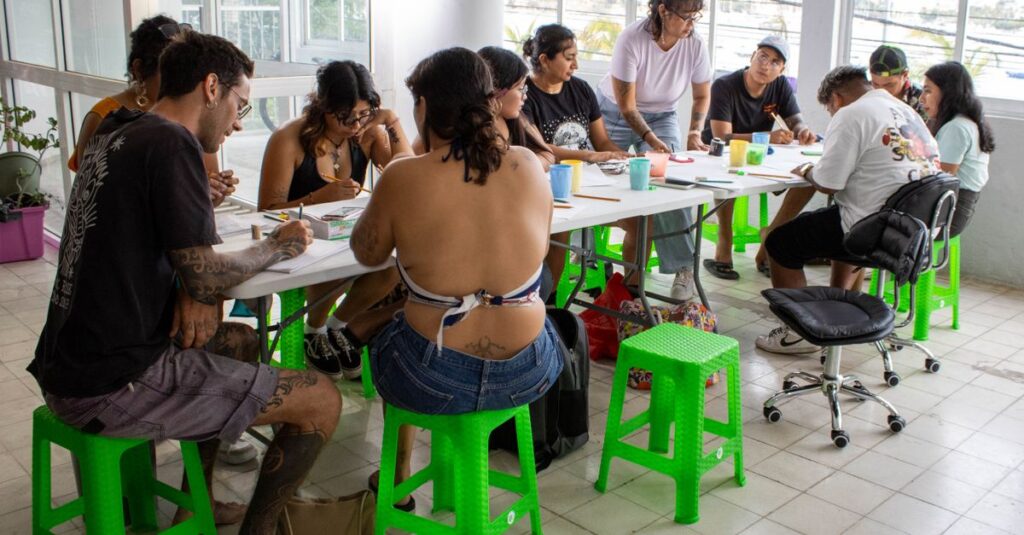 Group of adults engaged in a creative workshop indoors in Acapulco, Mexico.