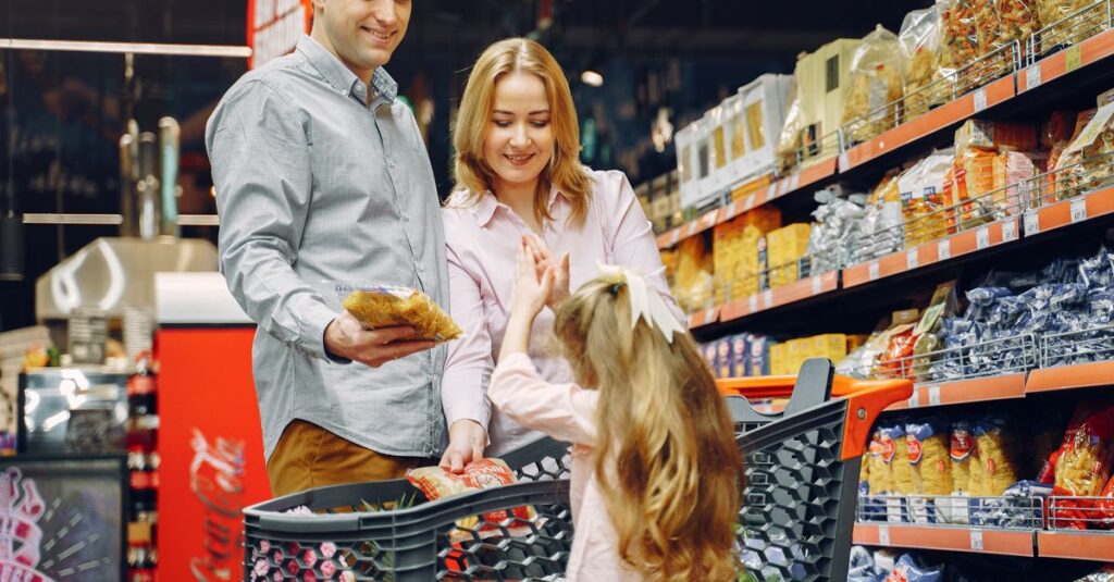 A happy family shopping together in a supermarket aisle, sharing a joyful moment.