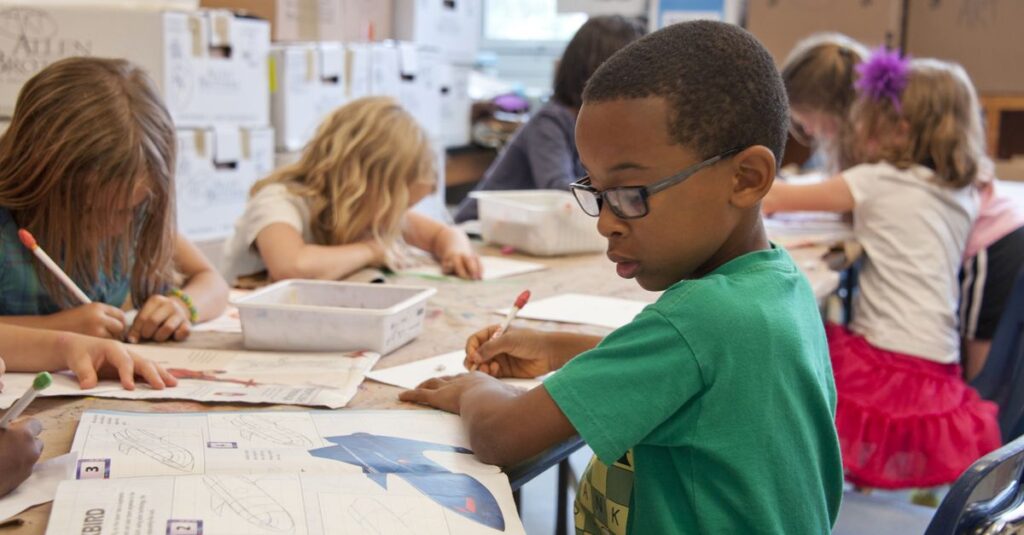 Group of children focused on educational activities in a classroom setting.