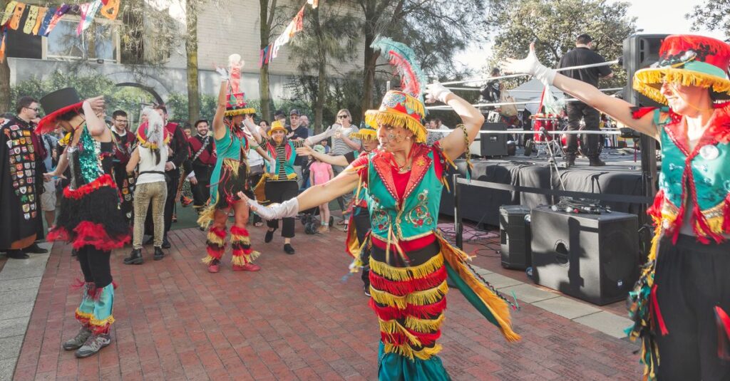 Vibrant street parade with dancers in traditional colorful costumes celebrating outdoors.