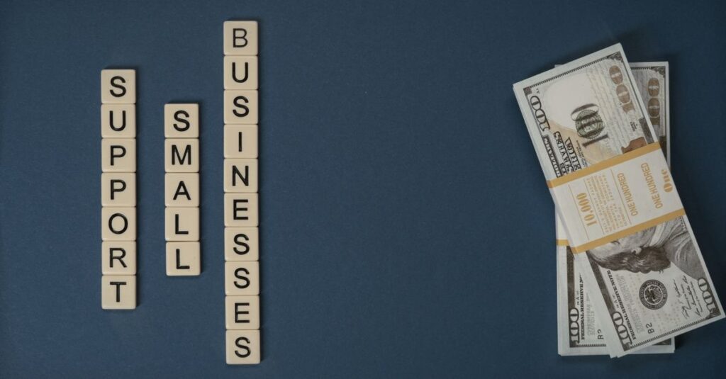 Conceptual image of supporting small businesses with financial resources using money and letter tiles.