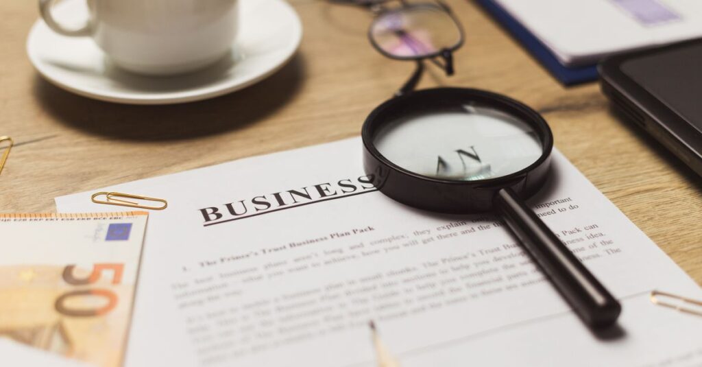 A business workspace setup featuring documents, coffee, and financial elements.