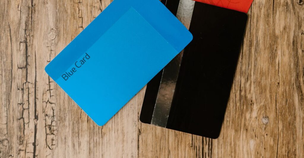 Flat lay of a red wallet and credit cards on a rustic wooden surface, offering room for text.