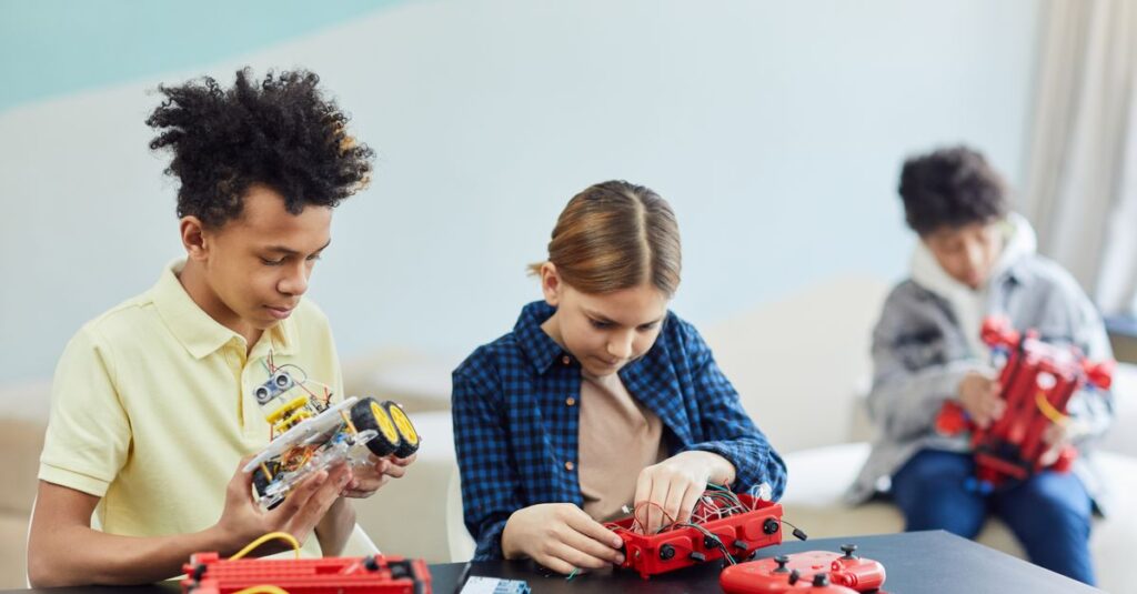Three teenagers concentrating on robotics projects in a bright, indoor setting.