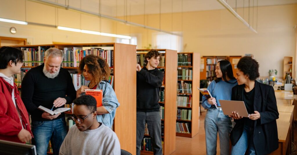 A diverse group of students engage in study activities in a bright library setting.