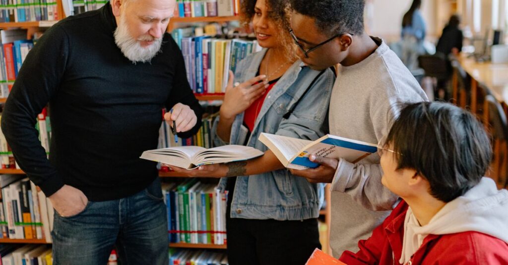 Four diverse students engaged in a collaborative study session in a library setting.