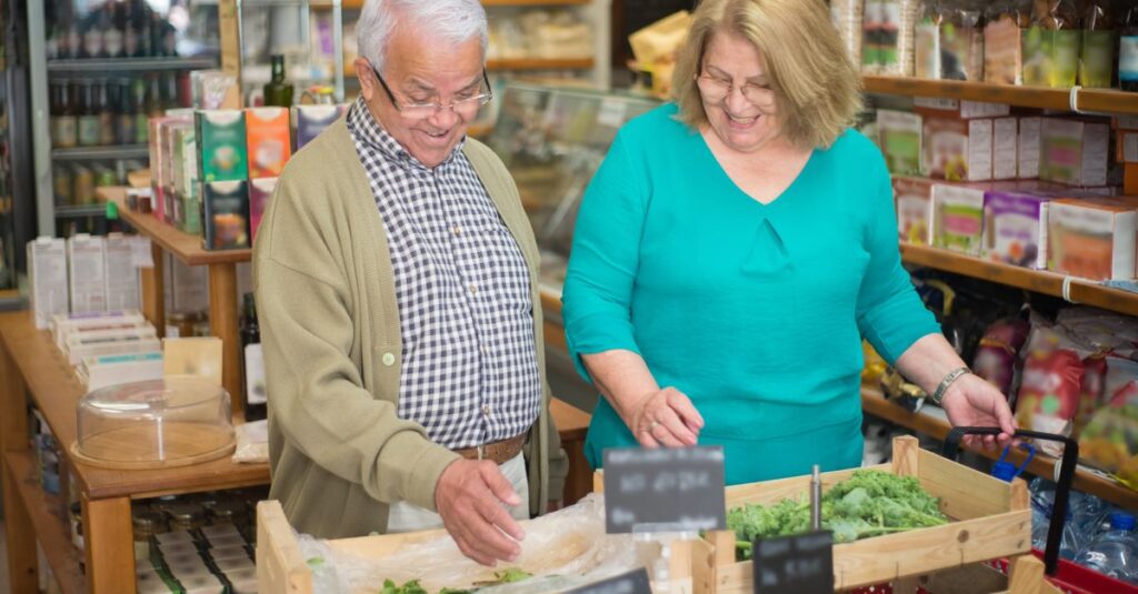 Smiling elderly couple grocery shopping, selecting fresh produce in a Portuguese store.