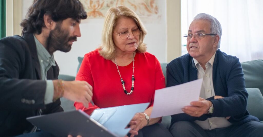 Senior couple consulting with a professional advisor, discussing documents indoors.