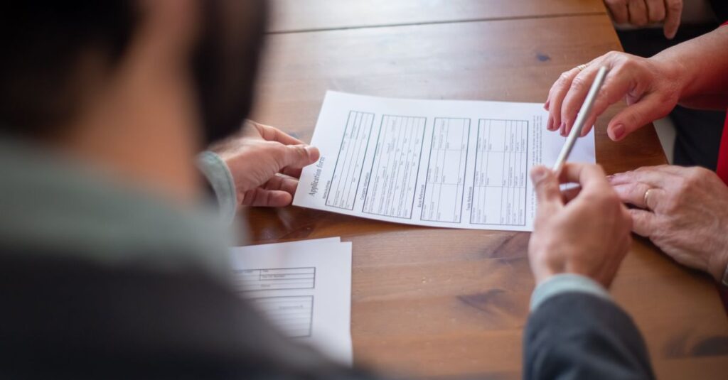 Close-up of business professionals reviewing documents at a meeting.