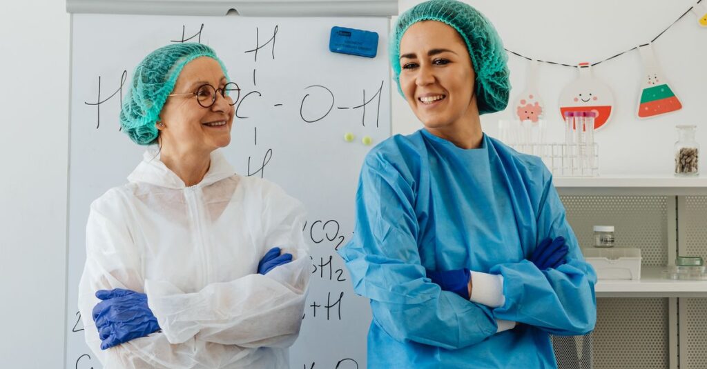 Two scientists in lab attire discussing research in a laboratory setting.