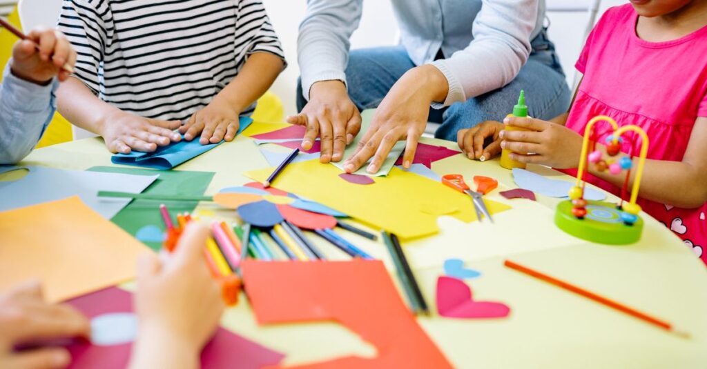 Group of diverse children enjoying creative art activities in a vibrant classroom setting.