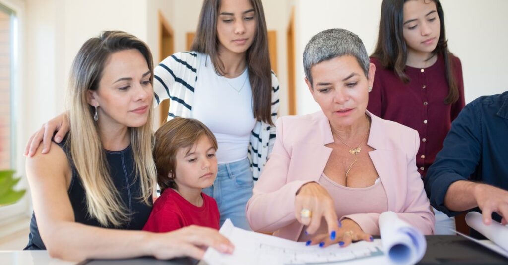 A family group reviewing real estate documents with a realtor indoors.