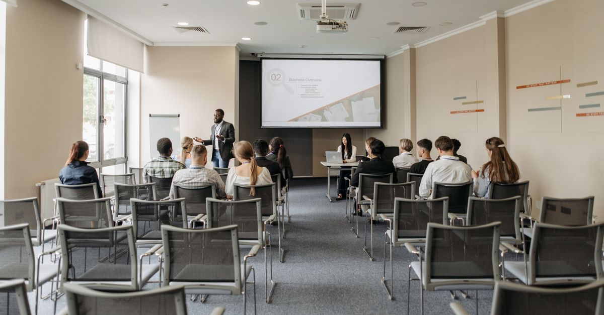 A group attending a business presentation in a modern conference room with projector.