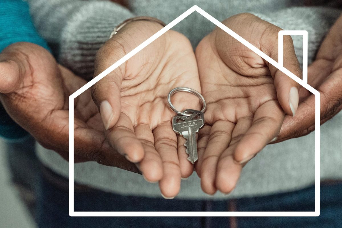 Hands of a couple holding a house key symbolizing home ownership and new beginnings.